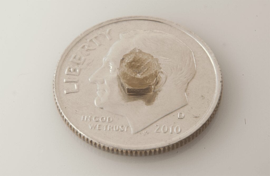 Wireless interstitial fluid pressure sensor shown to scale on a dime.
