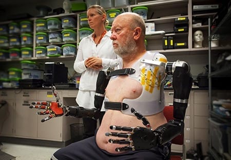 APL prosthetist Courtney Moran looks on as Les Baugh tests out the Modular Prosthetic Limbs.