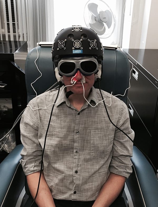 A staffer in Dr. Margaret Naeser's lab demonstrates the equipment built especially for the research: an LED helmet (Photomedex), intranasal diodes (Vielight), and LED cluster heads placed on the ears (MedX Health). The real and sham devices look identical. Goggles are worn to block out the red light. The near-infrared light is beyond the visible spectrum and cannot be seen. (Photo courtesy of Naeser lab)