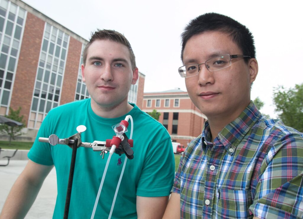 Doctoral students Billy McCulloch (left) and Mingzhe Yu (right) of The Ohio State University with a prototype of the new aqueous solar flow battery. CREDIT Image by Kevin Fitzsimons, courtesy of The Ohio State University.