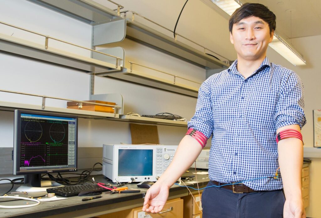 Jiwoong Park, an electrical engineering Ph.D. student and first author of the study, demonstrates communication from arm to arm using the magnetic field human body communication prototype developed in Mercier's Energy-Efficient Microsystems Lab at UC San Diego. 