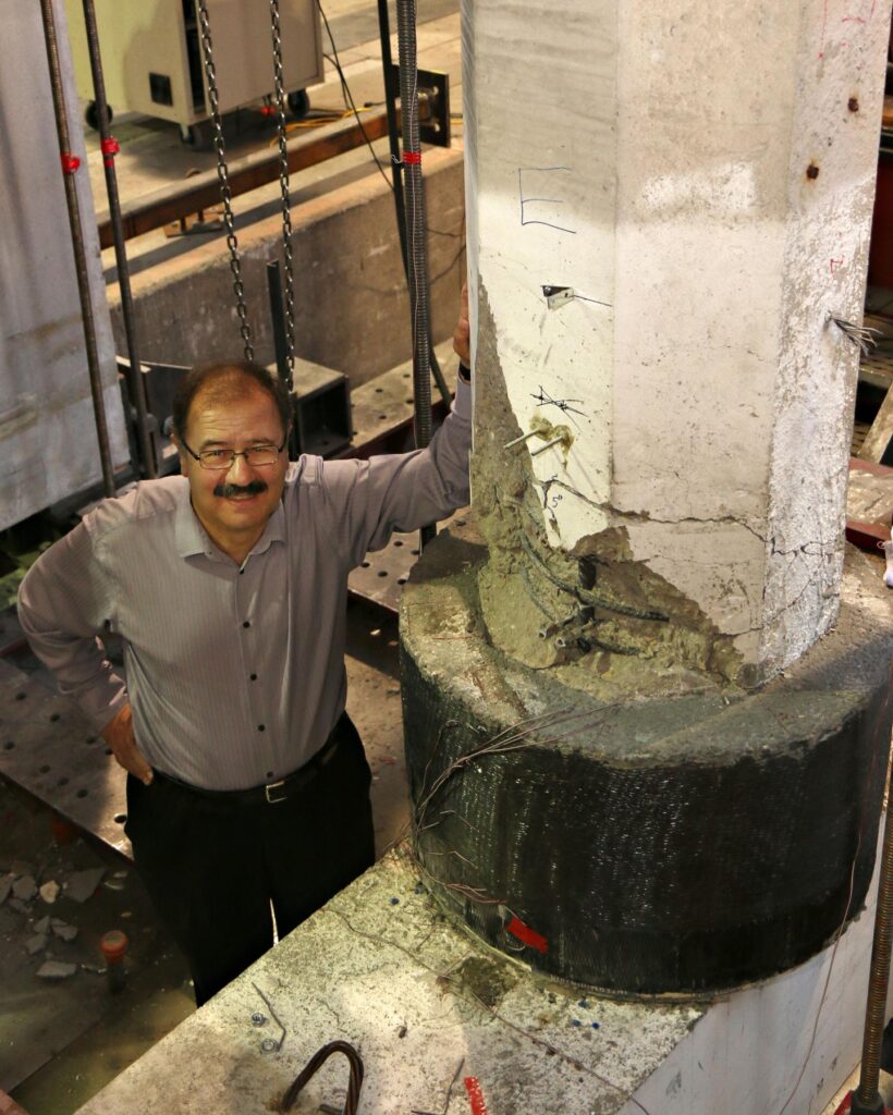 University of Utah civil and environmental professor Chris Pantelides stands next to a donut-sized "repair" he and a team of researchers designed that can fix a damaged column on a bridge. The repair -- a black concrete donut surrounding the ends of the column and wrapped with a composite fiber material -- can be deployed on bridges damaged in an earthquake much more quickly than through the standard procedure. CREDIT University of Utah College of Engineering