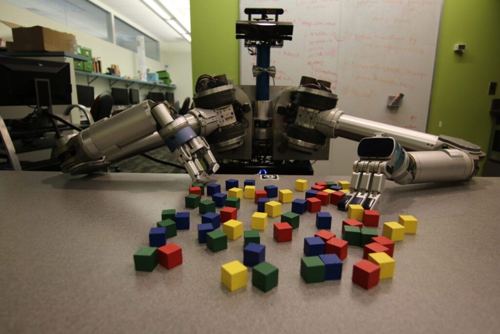 CMU researchers have developed an algorithm to help mobile robots decide which objects need to be picked up and moved and which ones can be safely pushed aside to accomplish a task. Here, the robot HERB uses it to pick up blocks
