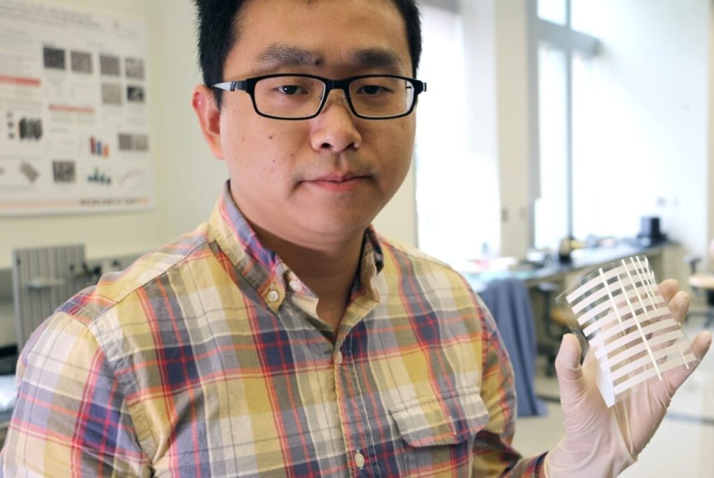 Post-doctoral researcher Congcong Wu, who is working in the lab of Shashank Priya, the Robert E. Hord Jr. Professor of Mechanical Engineering, holds up a layer of the flexible solar panel the group is working on. The process to adhere a thin film of titanium oxide to the panel takes less than 10 seconds using screen-printing technology.