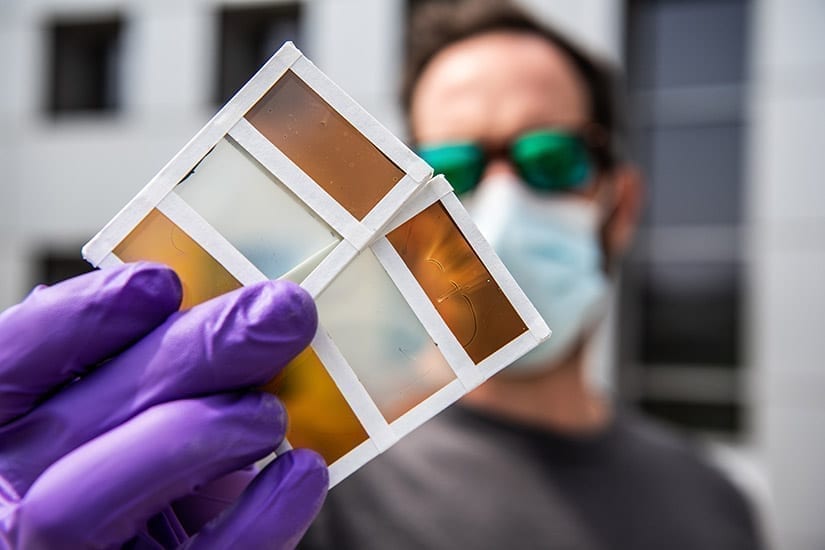 NREL researcher Lance Wheeler holds samples of perovskite-based window technology. Photo by Dennis Schroeder, NREL