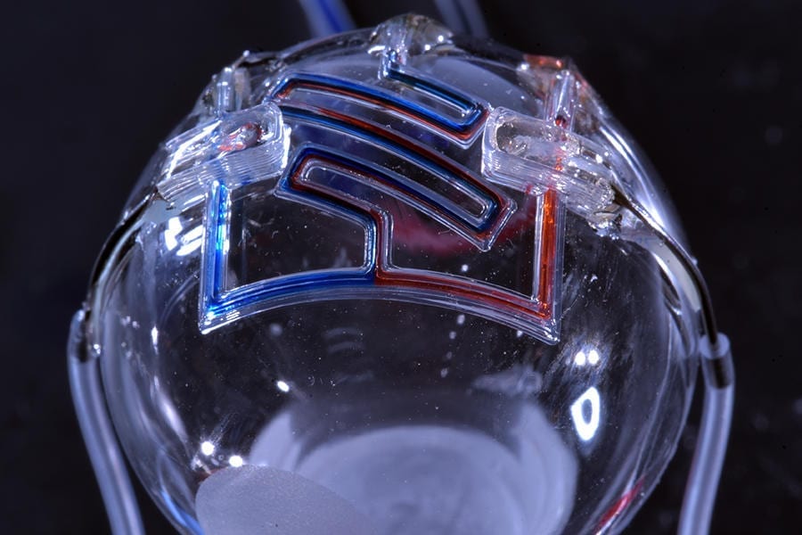 Researchers at the University of Minnesota are the first to 3D print microfluidic channels on a curved surface, providing the initial step for someday printing them directly on the skin for real-time sensing of bodily fluids. Credit: McAlpine Group, University of Minnesota