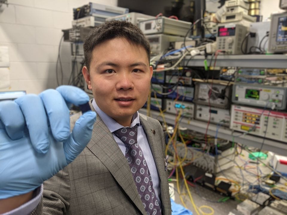 Dr Xingyuan (Mike) Xu with the integrated optical microcomb chip, which forms the core part of the optical neuromorphic processor.