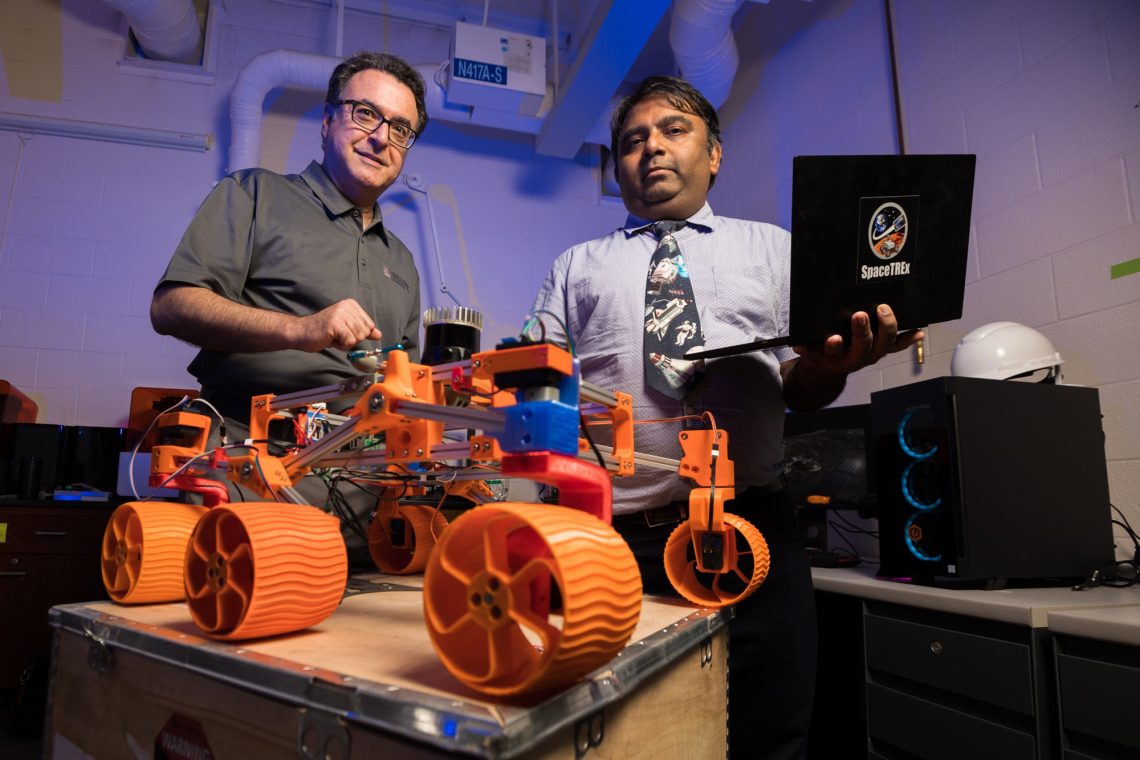 University of Arizona engineering faculty members Jekan Thanga (right) and Moe Momayez have received $500,000 in NASA funding for a new project to advance space mining methods that use swarms of autonomous robots. They are pictured with a low-cost, rapidly designed, 3D-printed rover prototype used for testing a new generation of miniature sensors for applications in lunar mining.Chris Richards/University of Arizona