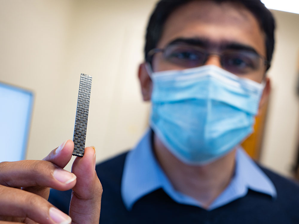 ME Assistant Professor Aniruddh Vashisth holds a sample of a healable carbon fiber composite material that his team is studying. Photo by Andy Freeberg / University of Washington