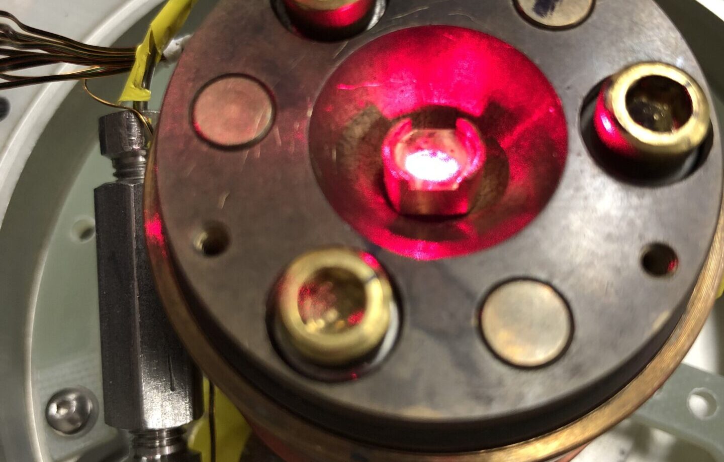 A strong laser is seen illuminating a material in a low-temperature chamber. The laser is being used to change the material's degree of transparency.
Credit: Caltech/David Hsieh Laboratory