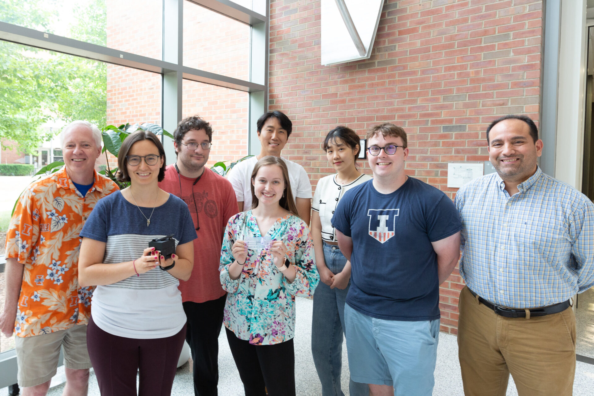 From left: Brian Cunningham, Amanda Bacon, Aaron Jankelow, Katherine Koprowski, Han Keun Lee, Weijing Wang, Robert Stavins, and Enrique Valera. Bacon and Koprowski are holding the instrument and the cartridge, respectively. CREDIT Julia Pollack
