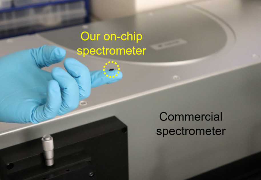 A fingertip-sized on-chip spectrometer in the foreground compared to a commercial benchtop-size spectrometer in the background. Photo: Aalto University