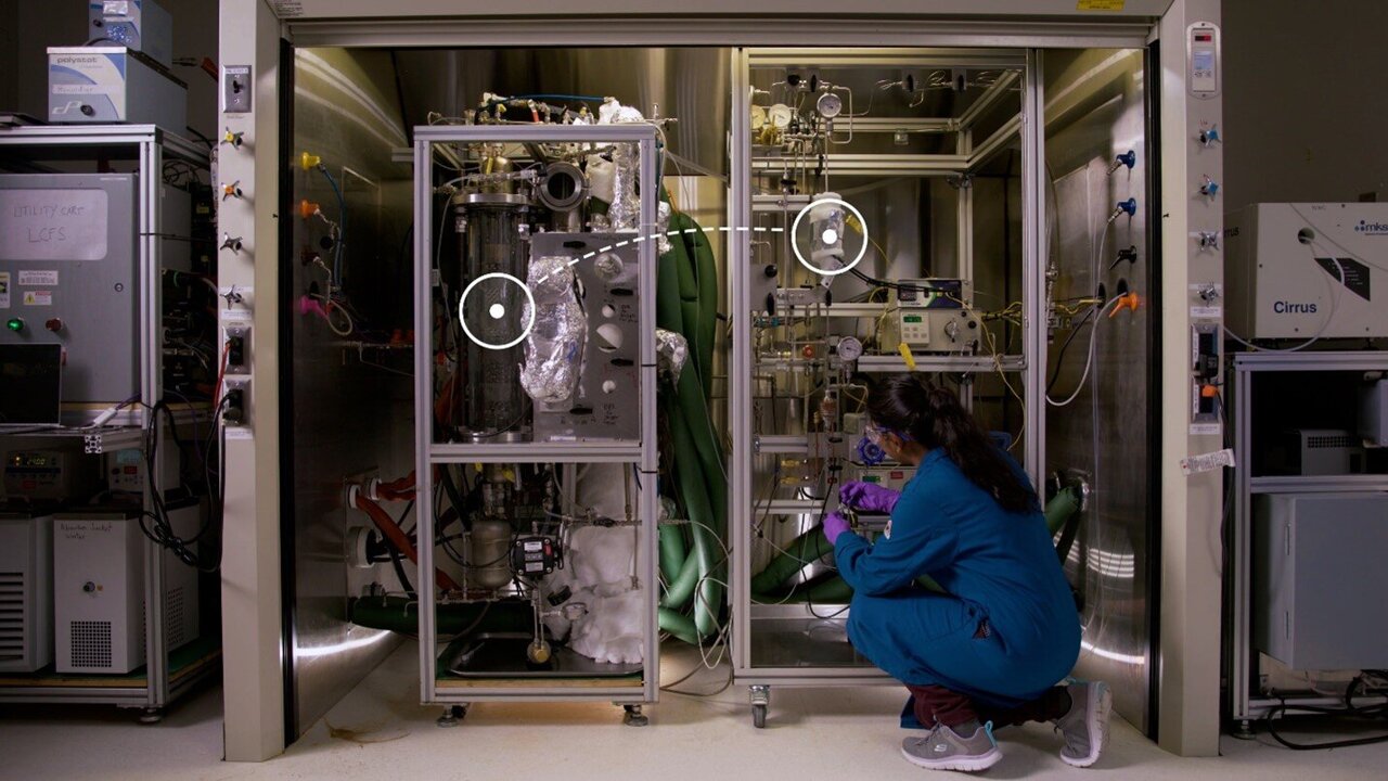 Taking up only as much space as a walk-in closet, a new carbon capture and conversion system is simple and efficient at removing carbon dioxide from gas that's rich with carbon dioxide. On the left of this walk-in fume hood, "smoke" moves through a cylindrical container where it makes contact with a carbon-capturing solvent. That solvent chemically binds to carbon dioxide and, on the right, is converted to methanol. (Photo by Eric Francavilla | Pacific Northwest National Laboratory)