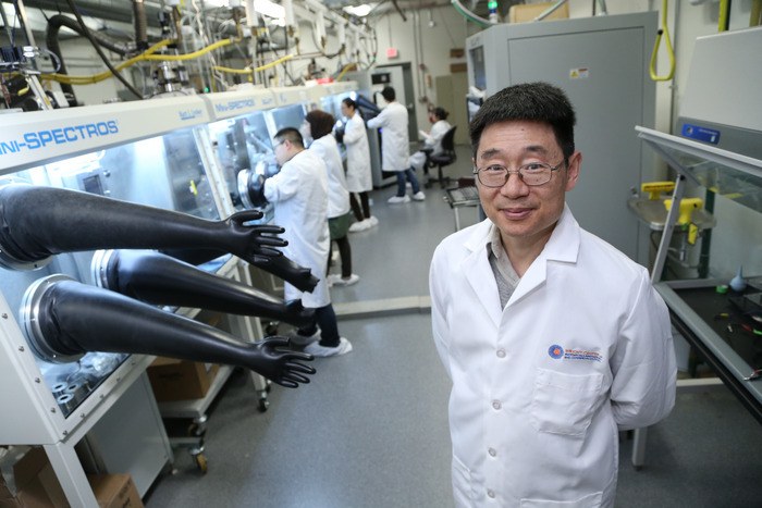 Dr. Yanfa Yan, professor of physics, with his perovskite solar cells which are able to increase the total electrical power generated by using two parts of the sun's spectrum