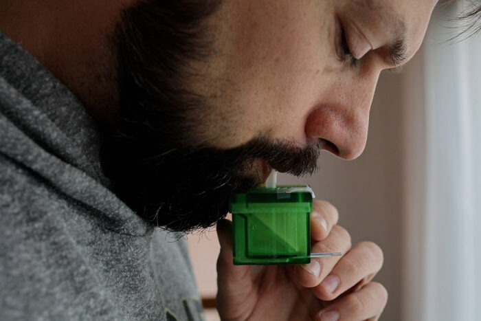 Benjamin Sumlin, PhD, a senior scientist at Washington University in St. Louis, blows into a device designed by researchers at the university. The device — a breath test that uses a biosensor — could become a tool for use in doctors’ offices to quickly diagnose people infected with the virus that causes COVID-19.